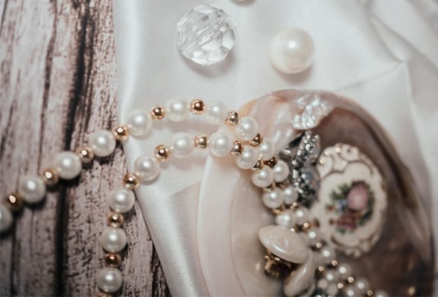Vintage handmade pearl and crystal jewelry on rustic wood fabric